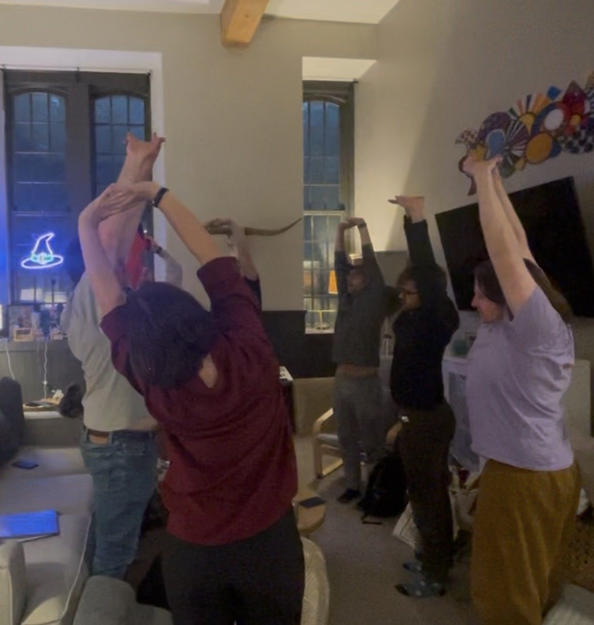 Ensemble members stretch together at a gathering