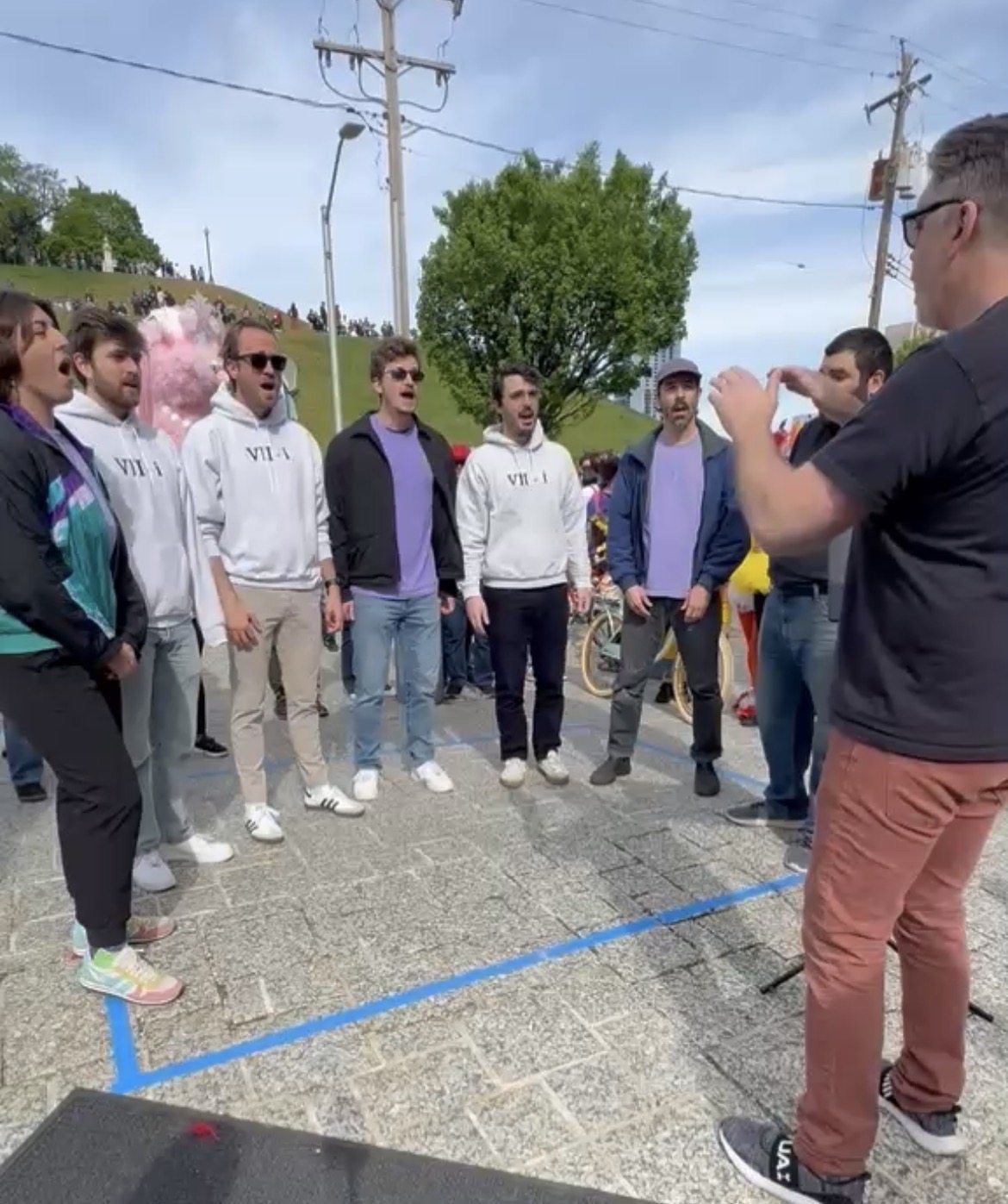 The ensemble sings together at an outdoor event